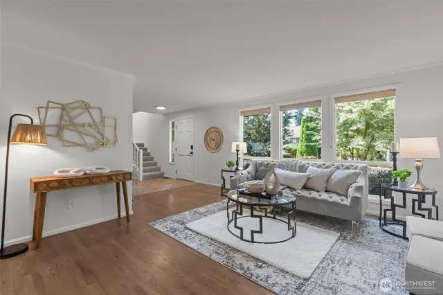 A perspective of the living room showing the natural light coming through the 3 very large southerly windows.