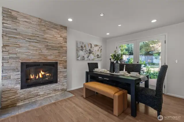 The dining room graced by a cozy gas fireplace and a beautiful backyard.
