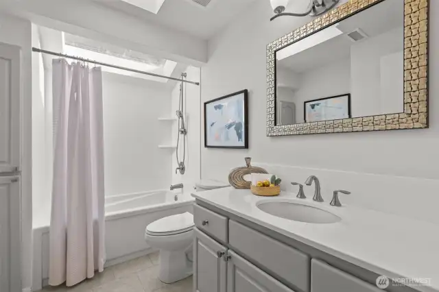 The main bathroom, so much natural light you hardly need lights. Refreshed with counters and shower surrounds painted white with epoxy paint.