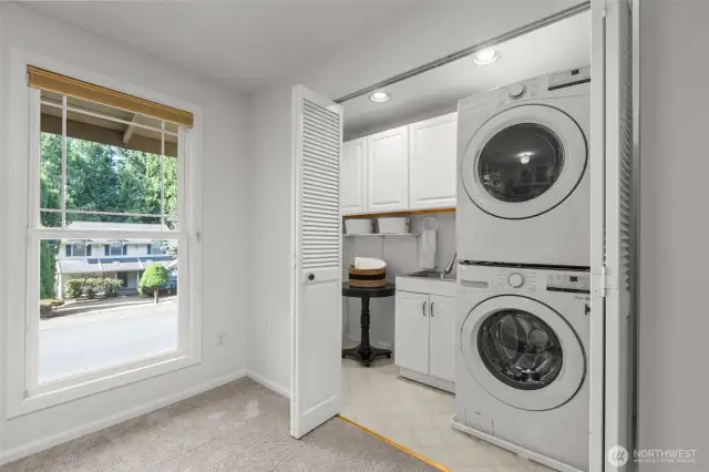 Utility closet with utility sink. Stacked appliances included.