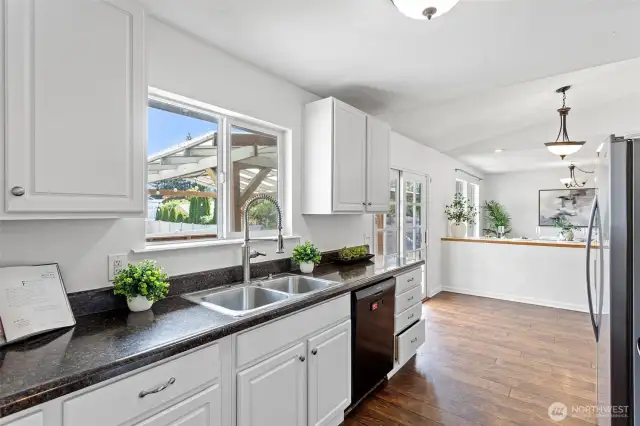 Large kitchen window and looks out to the fenced back yard.