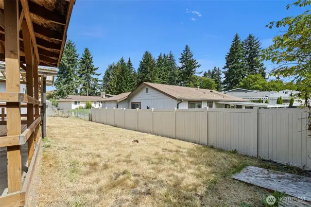 Full fenced back yard with storage shed and two covered porch areas