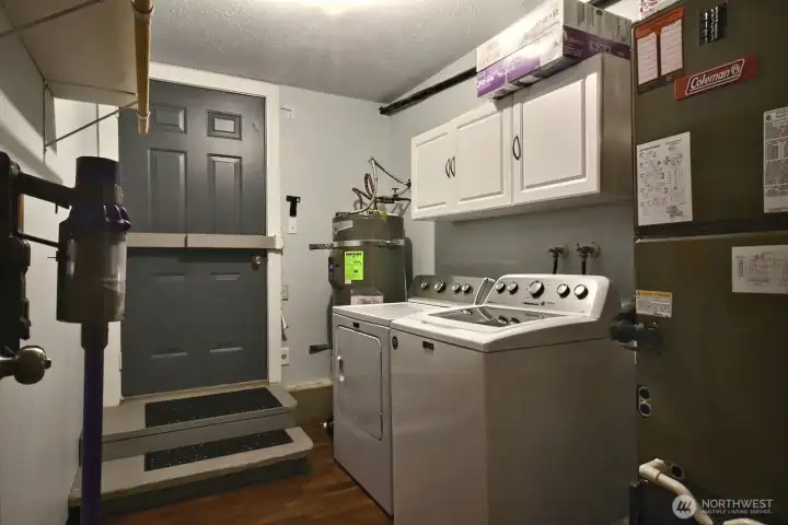 this utility room is so convenient with access to backyard, hot water heater and furnace.