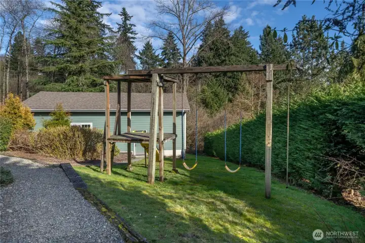 This view shows the detached shop across the side yard and play area.