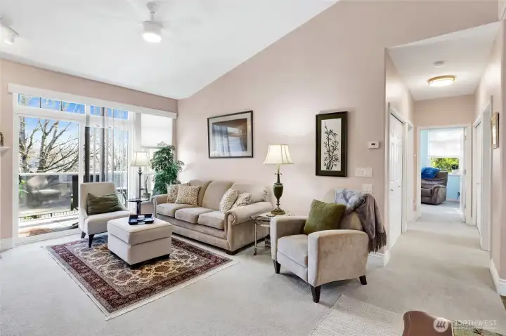 The living room features soaring vaulted ceilings and a cozy gas fireplace, creating a warm and inviting atmosphere. With its spacious layout, it’s the perfect place to relax or entertain guests.