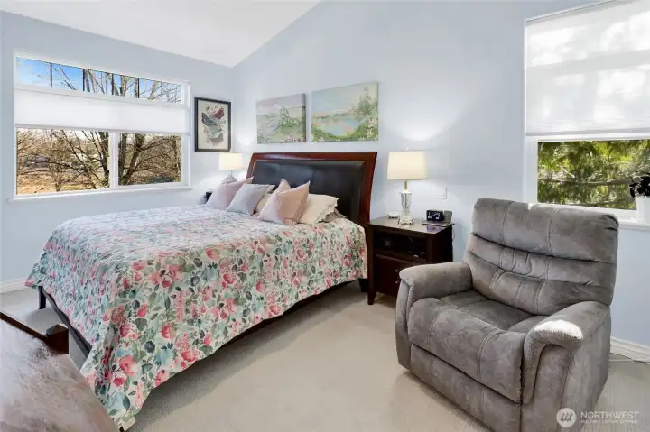 The primary bedroom features vaulted ceilings and a private ensuite bath for added comfort. As an end unit, it also enjoys an additional window that brings in even more natural light.