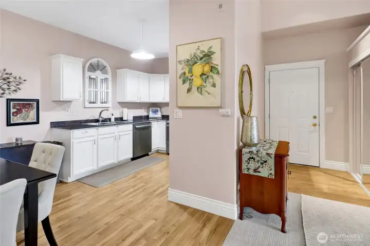 Looking from the hallway toward the front door. Kitchen/dining area on the left. Living room on the right.