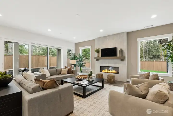 Cozy living room with gorgeous electric fireplace. Floor to ceiling tile and peaceful views make this the place to be! Huge double sliders lead to outdoor living and back yard.