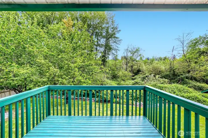 Spacious deck overlooks the lush backyard and greenspace.