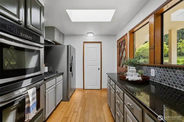 The heart of the home: A beautifully updated kitchen featuring sleek granite countertops and a stylish backsplash, with a walk in pantry for all of your storage needs.