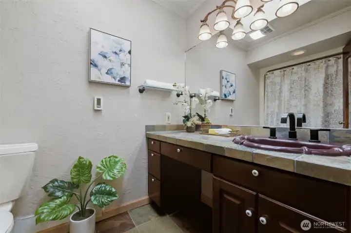 The private primary full bath features heated floors and a skylight for an abundance of natural light.