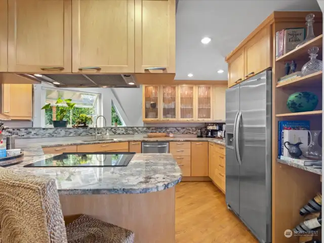 Gorgeous Kitchen had +$100K remodel - with granite counters, stainless appliances, custom cabinets with sea grass glass, lots of counter space & cabinets, sitting bar +separate area with Desk space & walls of cabinets with door leading out to side Deck.