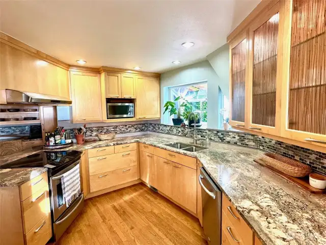 Gorgeous Kitchen had +$100K remodel - with granite counters, stainless appliances, custom cabinets with sea grass glass, separte desk area & lots of cabinets.