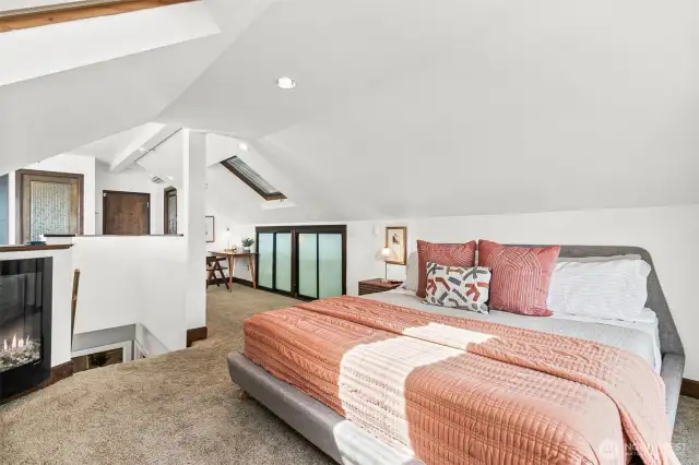 The primary bedroom features vaulted a fireplace, an en suite bath, a walk in closet, built-ins, and skylights. It's a unique and beautiful space.
