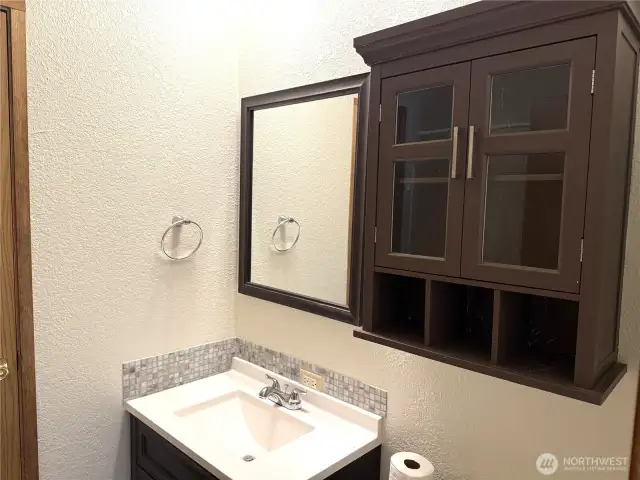 Full bathroom with access from mud room and hallway leading to the living room and bedrooms.