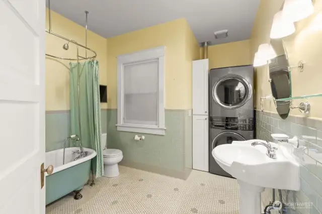 remodeled bath with new tile and original clawfoot tub, along with washer/dryer