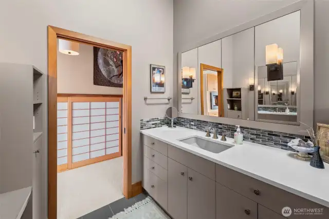 A thoughtful, low-maintenance bath pairs with hidden storage and a walk-in closet—subtly elevated by elegant Shoji screens.