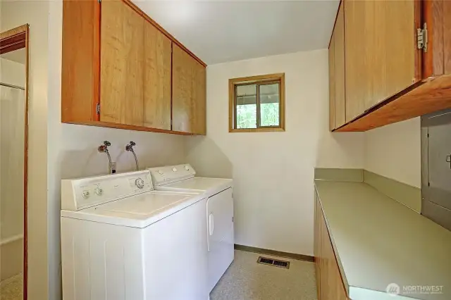 Utility room with washer and dryer included in addition to plenty of cabinet and storage space.