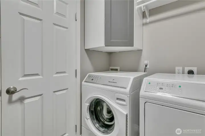 Laundry room with built-in cabinetry and shelving for organization.