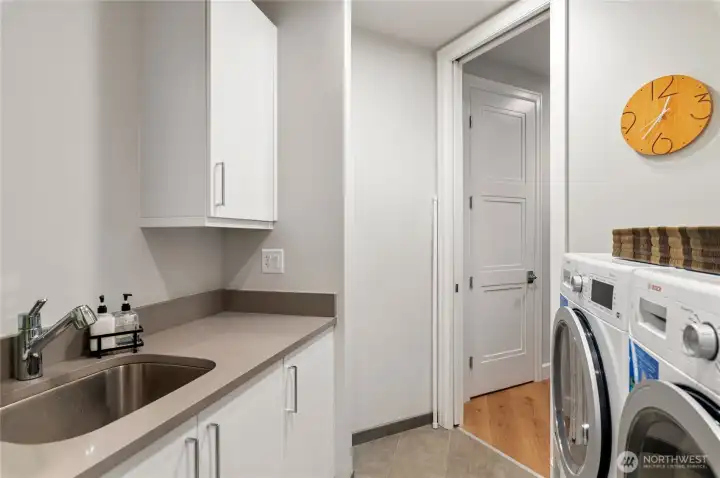 Well-appointed utility room featuring a deep sink, modern finishes, and convenient built-in storage. Walk-in pantry with built-in custom shelving.
