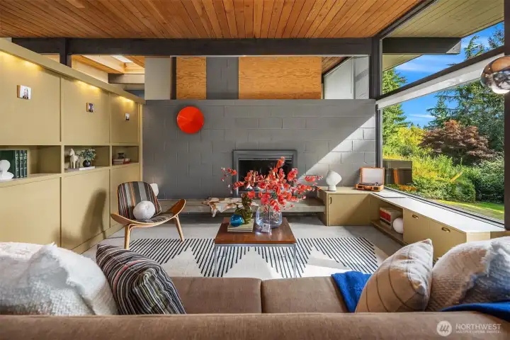 Two-sided shelving delivers useful beauty in the living room and entry.  A raised hearth extends to low cabinetry to deliver a remarkable amount of seating in the living room.