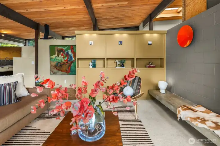 Looking back toward the entry, which is on the other side of the built-in shelving, underneath the skylight.  You can just glimpse the kitchen to the left.  Note the ingenious use of vaulted ceilings and pony walls to create architectural interest while also allowing light and air to flow freely.