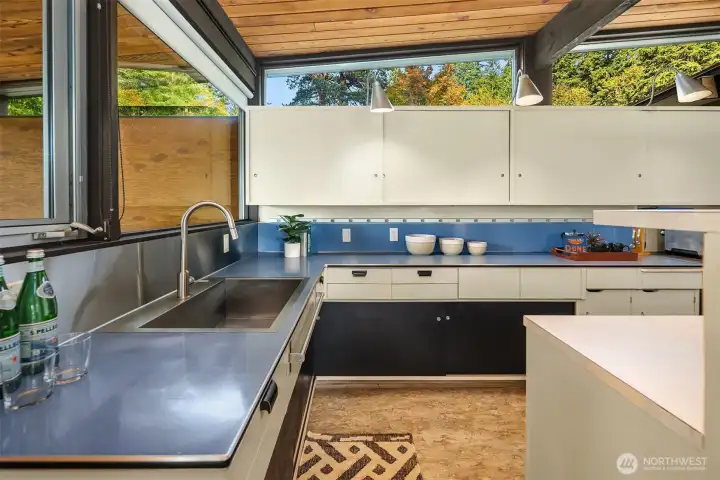 North-facing clerestory windows above the expanse of upper kitchen cabinets offer diffuse light and a seasonally-changing tableau thanks to the deciduous trees out front.