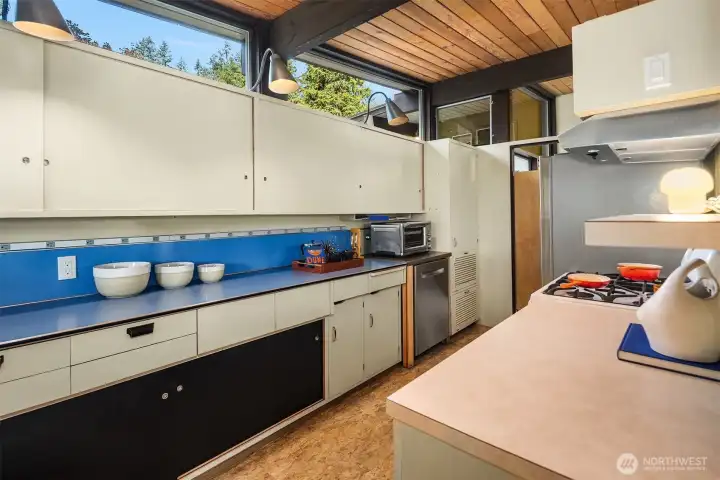 A saloon door tucks the kitchen away from the entry without making things feel closed off.  Another brilliant use of a pony wall here allows the kitchen to enjoy the beauty and light from the entry while still clearly defining itself as its own "room."