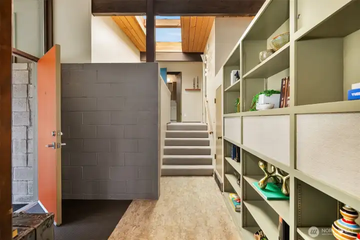 Stairs to the lower level are to the left just beyond the concrete entry wall.  A few stairs lead to two bedrooms and a 3/4 bath.  The door to the attached garage is just at the top of the stairs on the left.