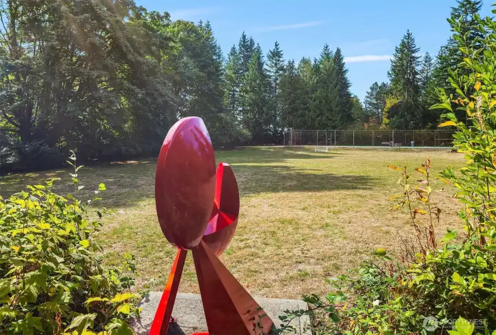 "Big Red" a sculpture by Charles W Smith (1922-2009) in 1963 looks upon the expansive community-only play grounds and tennis court.  The plaque reads:  "...a leading Northwest sculptor and an early member of Hilltop community.  He taught art and industrial design and the University of Washington for 47 years.  He loved this community and the friends he had here.