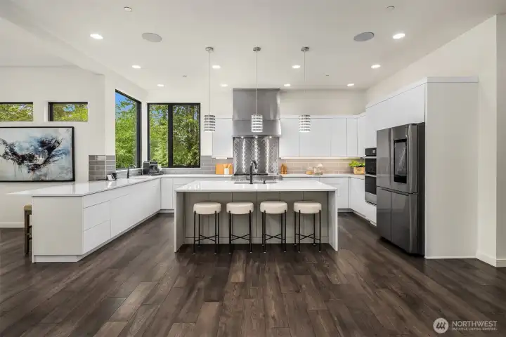 The chef’s kitchen is a dream — equipped with premium smart appliances, custom cabinetry, a walk-in pantry, and an oversized waterfall island perfect for gatherings.