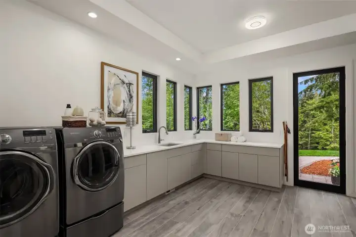 A utility room dream!  Wonderful light, access to yard and direct access to garage and tons of storage!