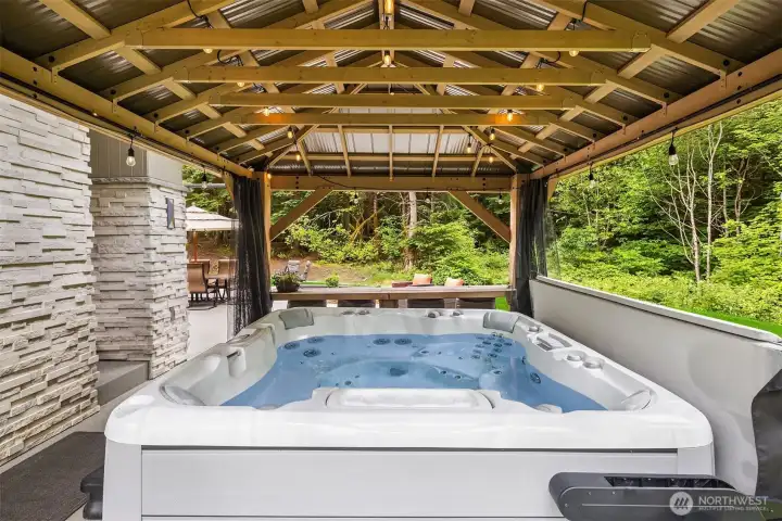 Relaxing year-round in the outdoor hot tub while taking in the tranquility of the surrounding evergreens.