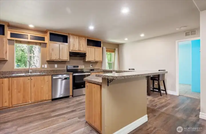 A bright, functional kitchen featuring newer appliances, a welcoming breakfast bar, and a little dining nook.