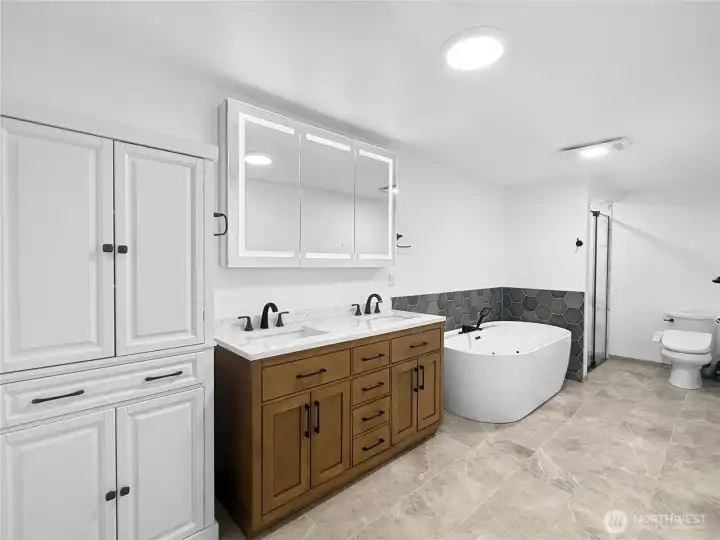 Luxury primary bath with heated tile floors and spa-inspired finishes. New double vanity with smart mirror and contemporary styling