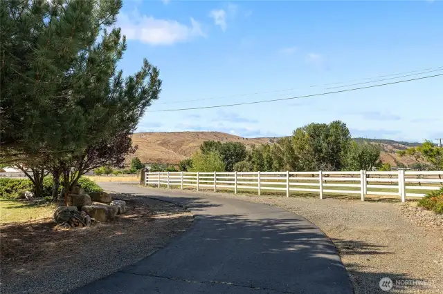 Paved circle driveway and white vinyl fence around the house and yard area!