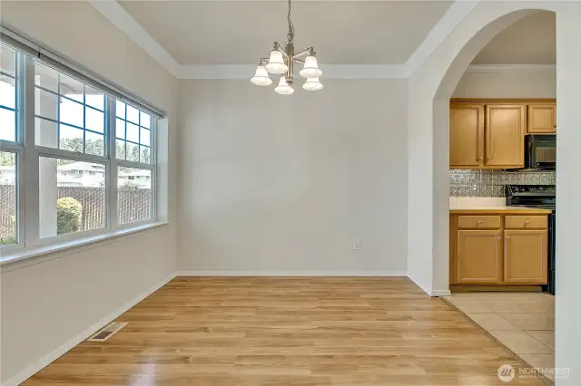 Dining room just off the kitchen with big picture window for natural light, crown moulding for an elegant feel ~