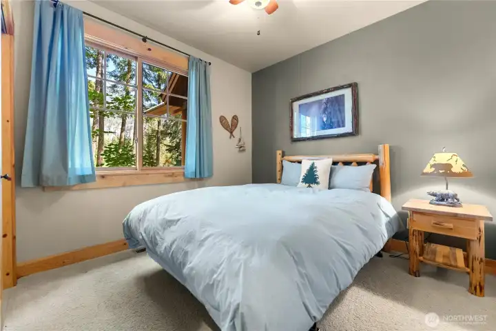 Inviting guest bedroom on the main level with warm natural light and serene mountain views.