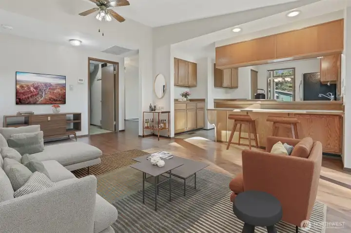 Family room with laminate hardwoods opens to kitchen with an eating bar and has sliding door to south facing deck.  Virtually staged photo.