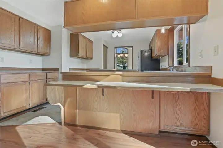 Kitchen features oak cabinets, stainless appliances including a newer kitchen aide downdraft range, an eating bar and opens to family room.