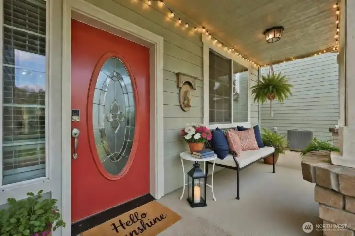 Step onto the covered front porch and feel instantly at home. A bold beautiful door with an elegant glass insert adds architectural character, while stone-accented columns and matching stone detail by the garage create timeless curb appeal. Soft evening lighting enhances the welcoming atmosphere, offering the perfect setting for seasonal décor or peaceful moments spent listening to birdsong.