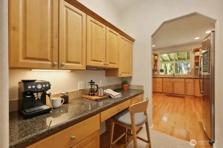 The butler’s pantry blends elegance and functionality, featuring granite countertops, built-in cabinetry, and a generous workspace perfectly positioned between the dining room and kitchen. Ideal for staging meals, storing fine dishes, or preparing drinks before dinner, it also adapts beautifully as a coffee bar or tucked-away desk area. A separate closet pantry on the opposite side provides additional storage, ensuring excellent organization and effortless flow for everyday living and entertaining.