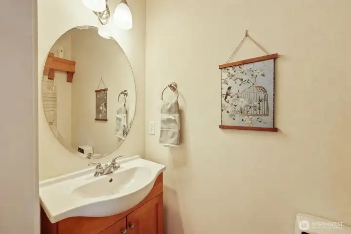 Unlike many homes, the main-floor powder room is finished with hardwood flooring, creating a seamless flow from the main living areas and reinforcing the home’s thoughtful design.