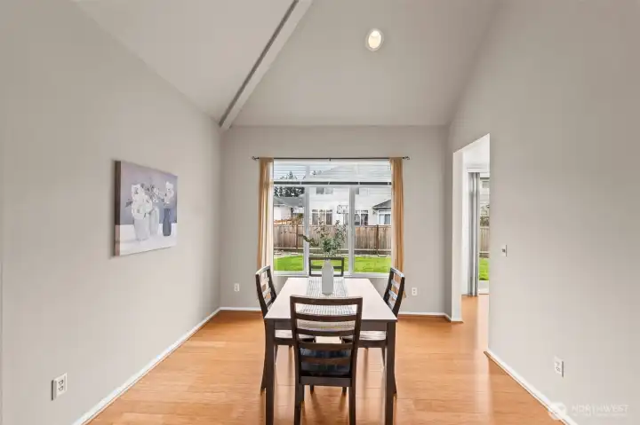 Dine in Style. This dedicated dining space features high, vaulted ceilings and a large window overlooking the private backyard. It’s an ideal setting for holiday meals or intimate dinners, bathed in soft, natural light by day and recessed lighting by night.