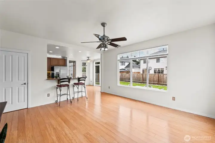Expansive Living. Experience the true meaning of an open floor plan in this sun-drenched great room. Large windows frame views of the private, fenced backyard, while the warm hardwood-style flooring and modern ceiling fan ensure comfort and style in every corner.