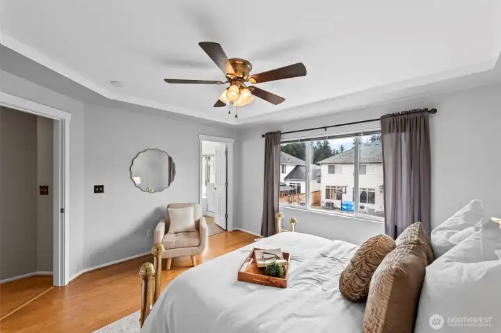 Bright and Airy. This view of the primary suite highlights the seamless flow into the ensuite bath. The recessed tray ceiling adds an extra layer of architectural sophistication, making the room feel even more expansive and luxurious.