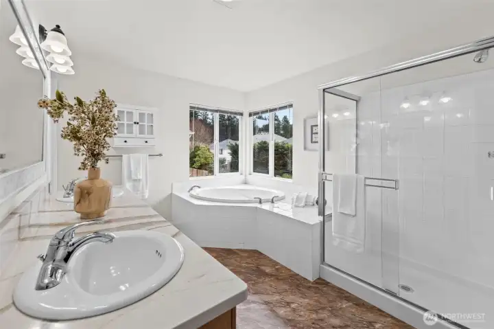 Spa-Like Luxury. Indulge in a true retreat within your own home. This expansive ensuite features a deep corner soaking tub framed by natural light, a separate glass-enclosed shower, and high-end marble-look countertops. It’s the perfect place to unwind after a long day.