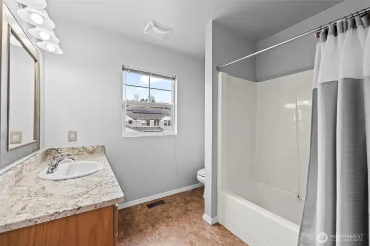 Complete Comfort. The upper-level guest bathroom is fully equipped with a tub-and-shower combo, a large vanity with granite-style countertops, and plenty of light. It’s perfectly situated to serve the secondary bedrooms.