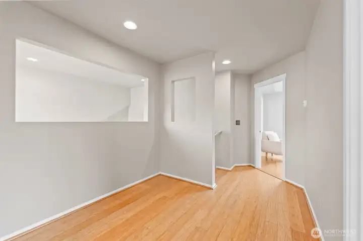 Architectural Detail. The spacious upper landing features a unique architectural cut-out that overlooks the living area below, maintaining an open connection between floors. This versatile space could easily accommodate a small reading nook or workstation.