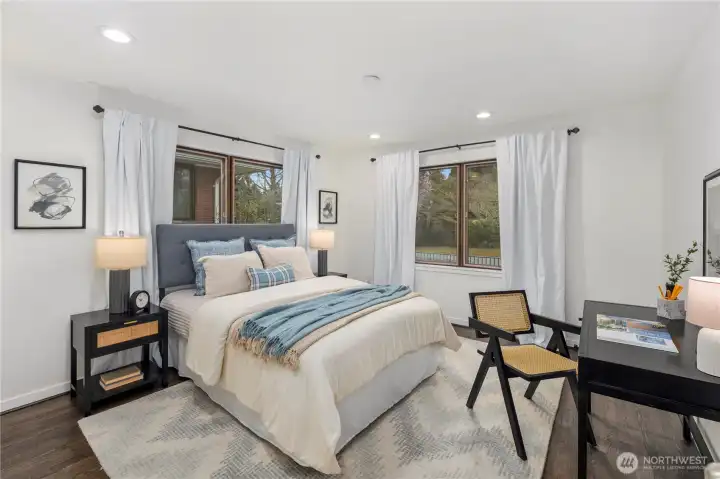 Bright and welcoming main-level guest bedroom offers abundant natural light and a comfortable retreat for visitors.